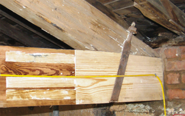Truss repair to tie beam showing a timber resin splice in position, shutter covers in wood and sdanded back smooth.